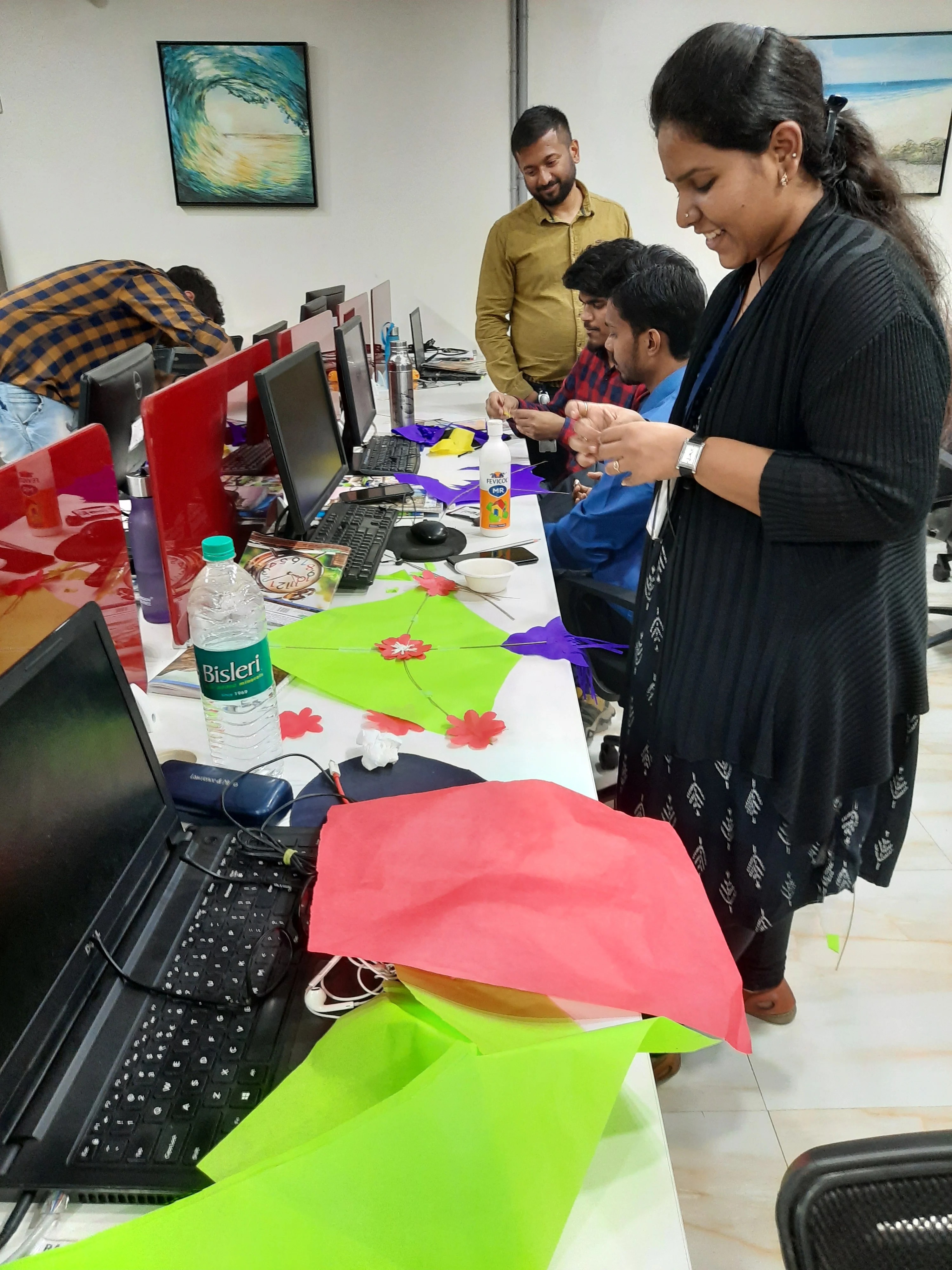 Colleagues making paper kites at their desks
