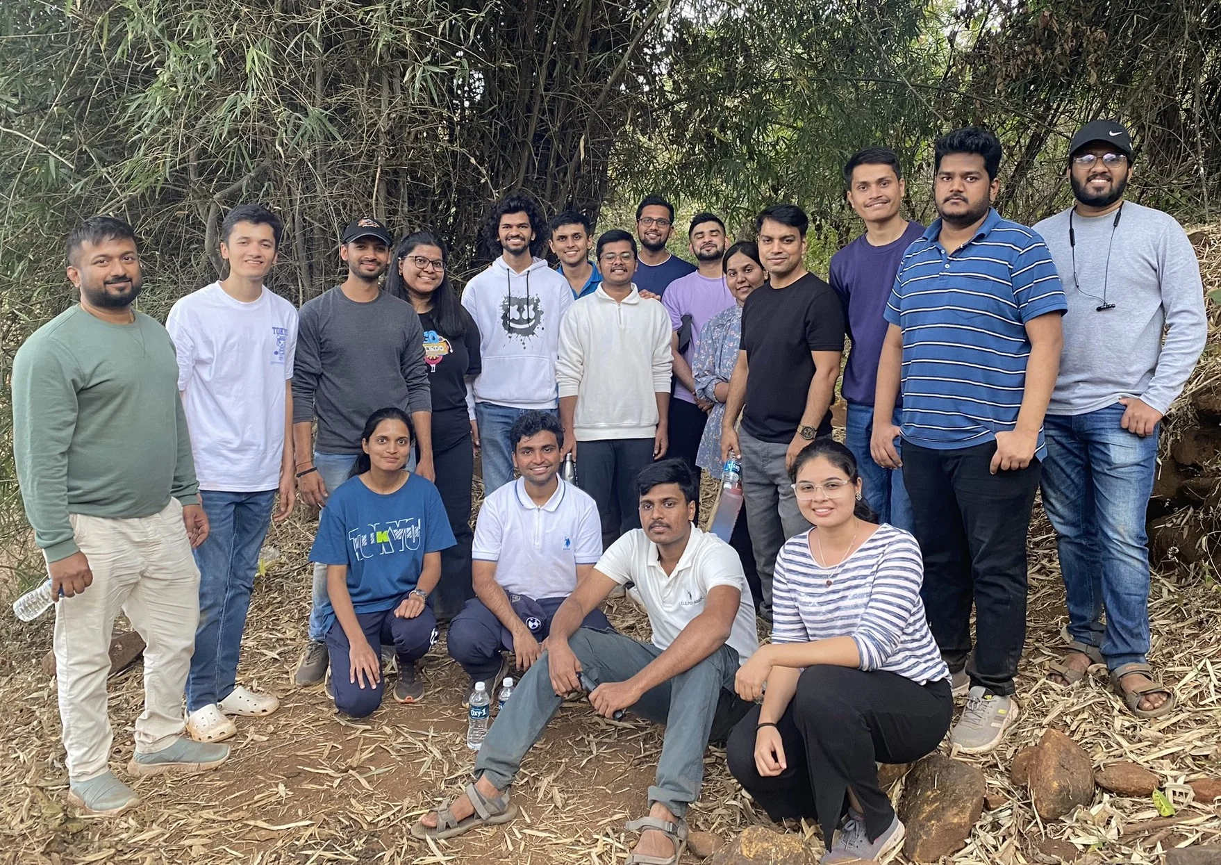 A smiling group of colleagues among trees on a day out