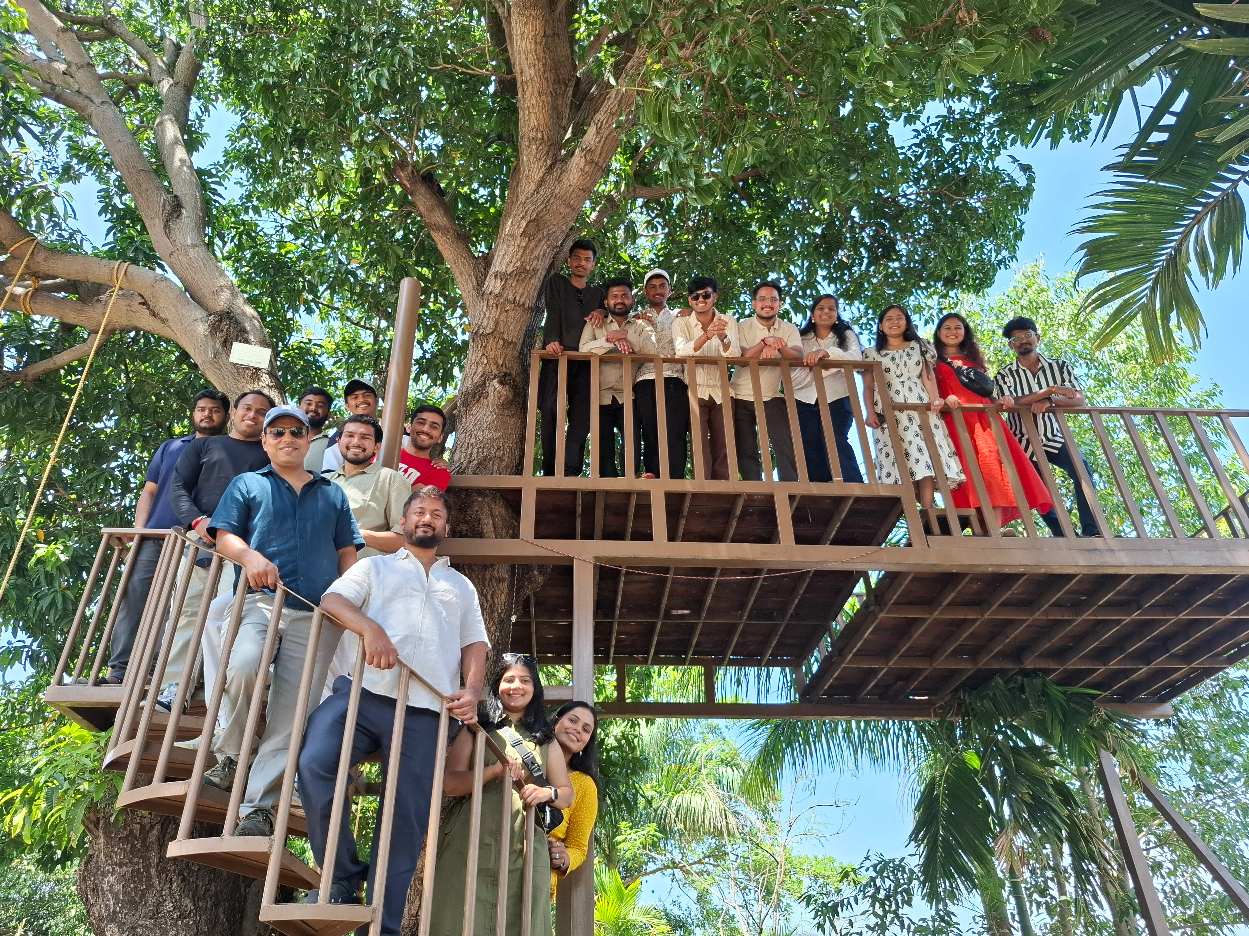 Team members on a treehouse platform and its stairs